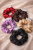 Jedwabne scrunchie na beżowym tle.png